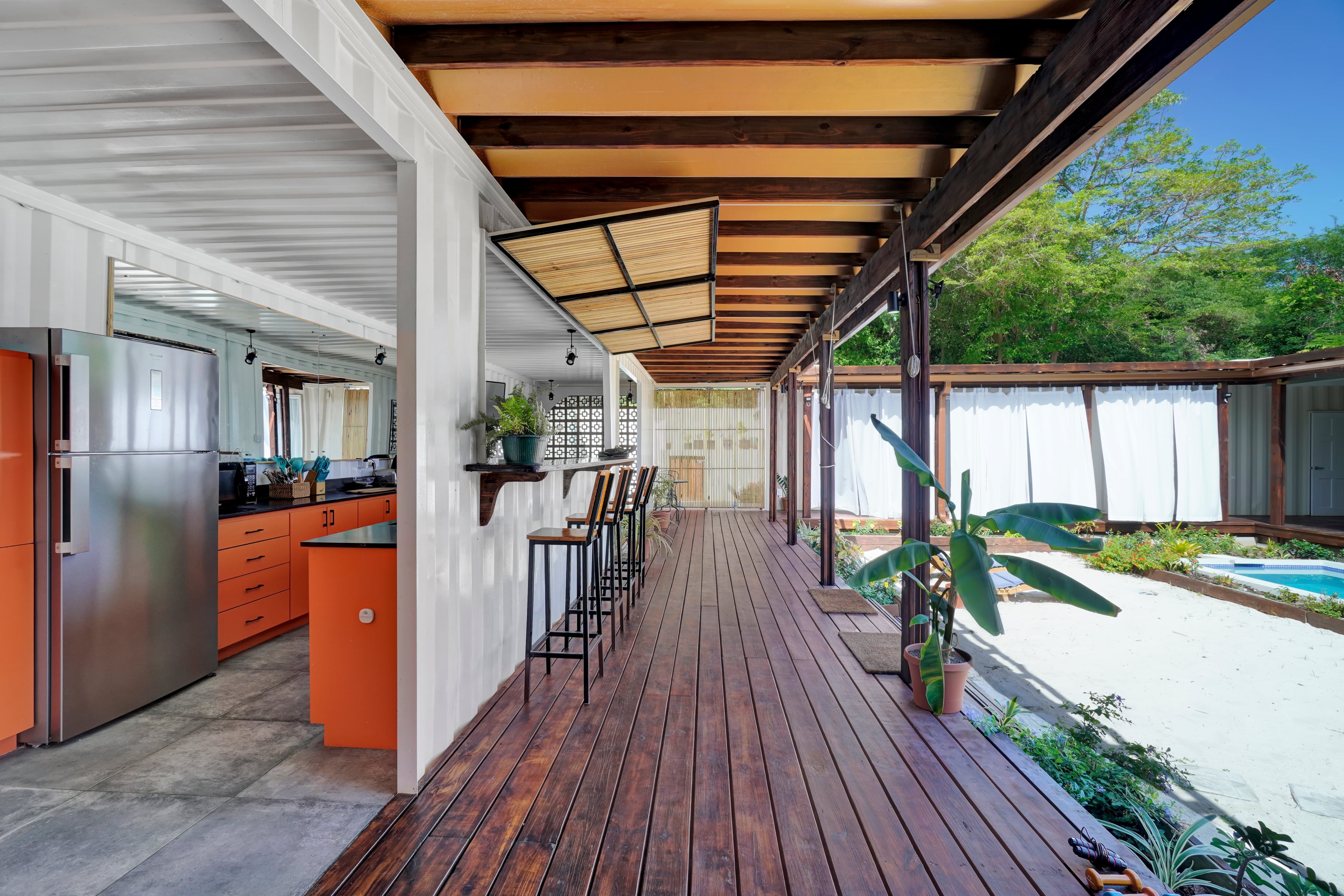 Corten Villa covered deck and outdoor dining area connecting to the pool