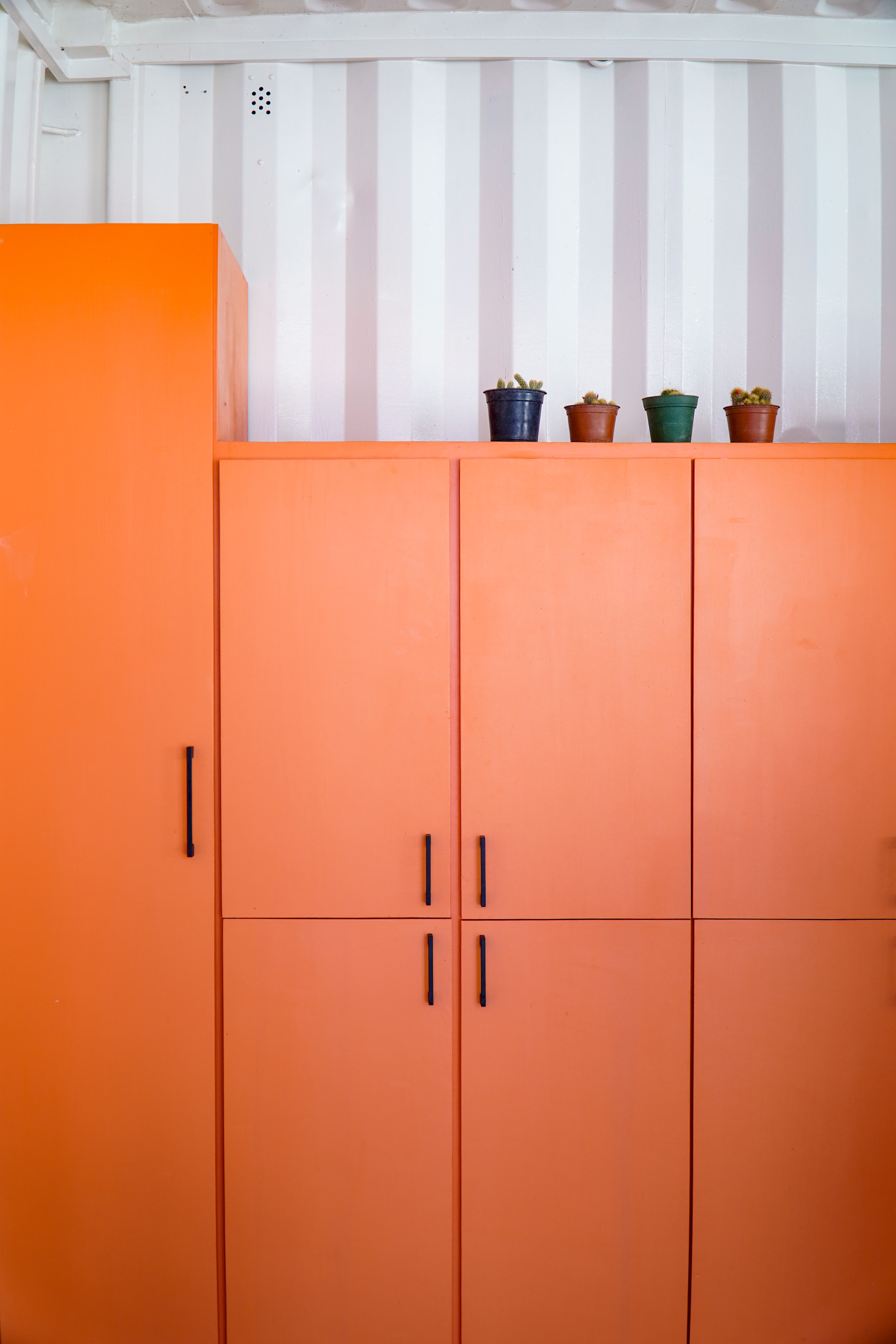 Orange cabinetry with container walls